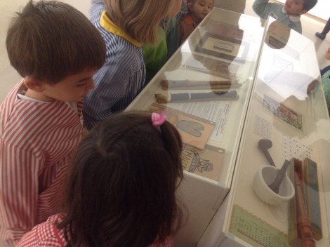 Niños y niñas observando una vitrina con objetos de Aurelio Suárez.